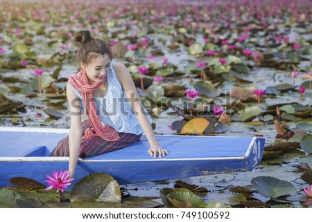 picture of beautiful woman with lotus flower,young woman relaxing with beautiful lotus flower field at the red lotus sea, Udon Thani, Thailand
