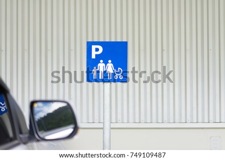 Blue car parking sign on empty parking lot for family with children.