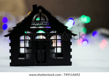 New Year's silhouette of the house and hearth against the background of a garland