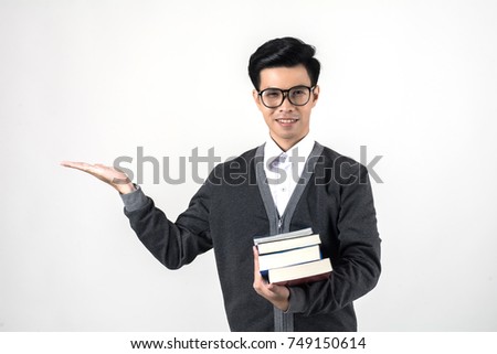 Young nerdy student is standing with books in glasses hand present something - copyspace