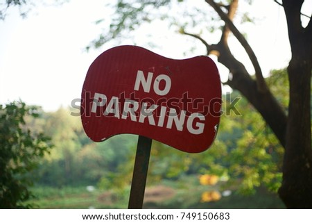 A closeup of a No Parking sign board outside a public garden in Mumbai.