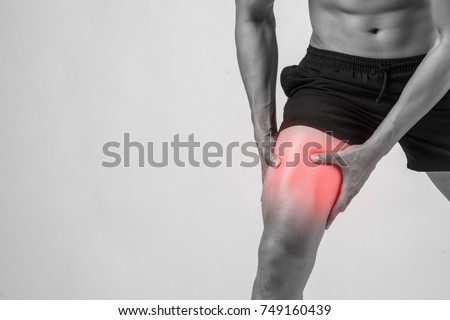 Young sport man with strong athletic legs holding knee with his hands in pain after suffering ligament injury  isolated on white. Royalty-Free Stock Photo #749160439