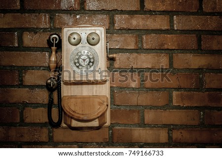 Urban background of a brick wall with an old out of service payphone