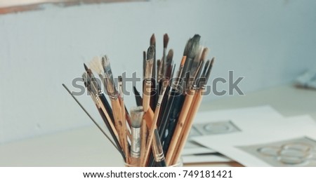 closeup of art tools in studio Paints, brushes, canvas, pencil