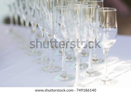 Horizontal photo of aligned empty wine glasses, close up, black and white. Selective focus.