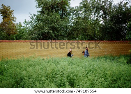A picture of a young romantic couple neat the wall in garden