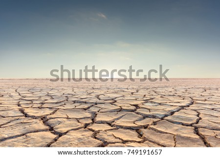 Soil drought cracked landscape on sunset sky Royalty-Free Stock Photo #749191657