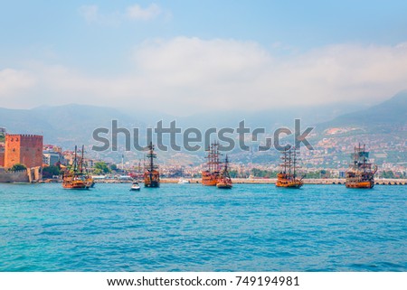 Pirate ships on the water of Mediteranean sea, near the Ruins of Ottoman fortress - Alanya