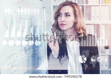 Concentrated and gorgeous businesswoman with red hair is holding a marker and looking at a scheme she drew. Toned image double exposure Elements of this image furnished by NASA