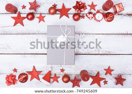 Christmas present on white wood table with ornament border in flat lay style