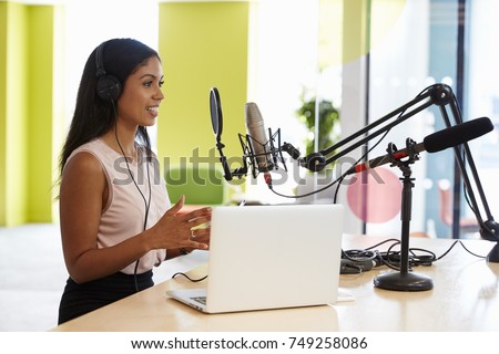 Young mixed race woman recording a podcast in a studio