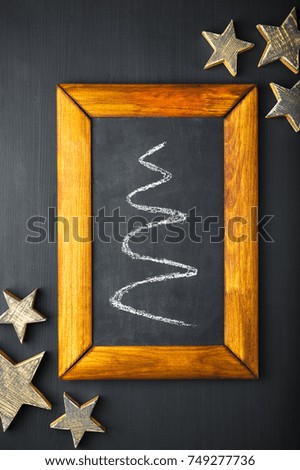 Christmas card rustic decoration in wooden frame, silhouette of the fir, Wooden Golden handmade star on dark background