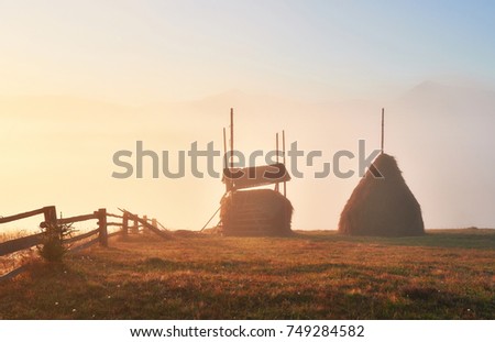 Amazing sunrise landscape with fog and a haystack in autumn. Location place Carpathian national park, Ukraine, Europe. Artistic picture. Beauty world.