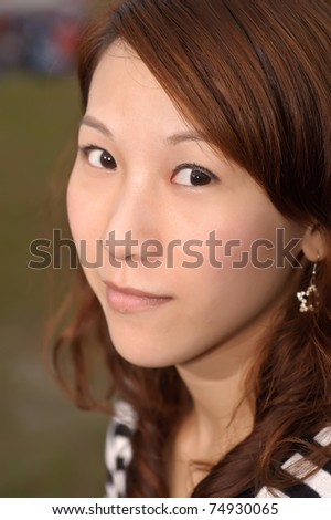 Closeup portrait of young Asian woman looking at you.