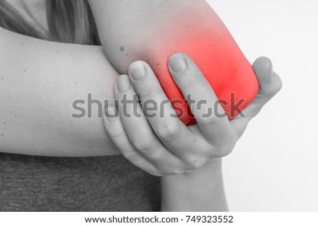 Woman with elbow pain is holding her aching arm - black and white photo