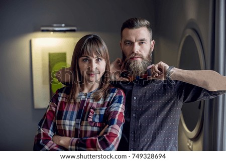 Portrait of a stylish couple in hipsters clothing. A man with a beard. The girl in a checkered shirt 