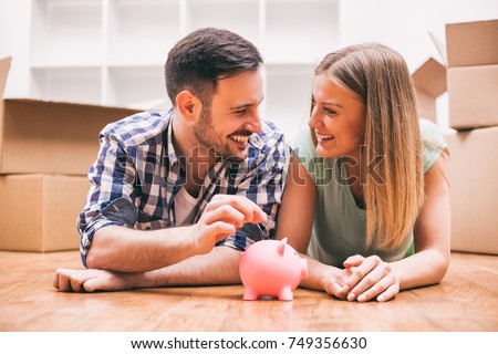 Young couple is saving money for their new home. Royalty-Free Stock Photo #749356630
