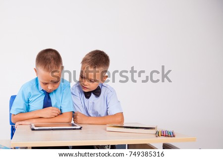 the two boys are looking at Internet Tablet school