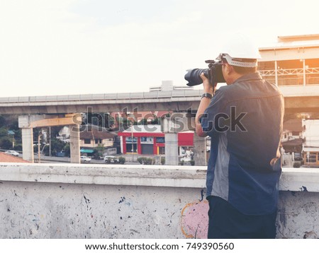 Young architect man working with camera, takes a picture for the job survey at construction site
