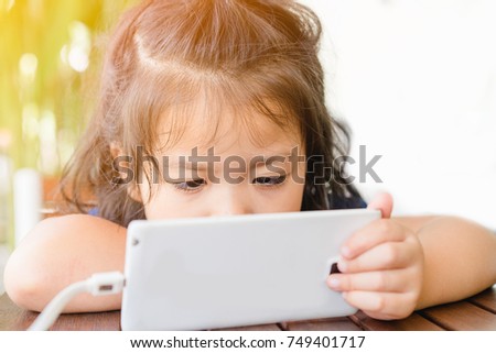 little girl watching cartoon on cellphone.