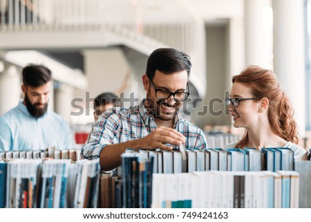 Young attractive students spending time in library