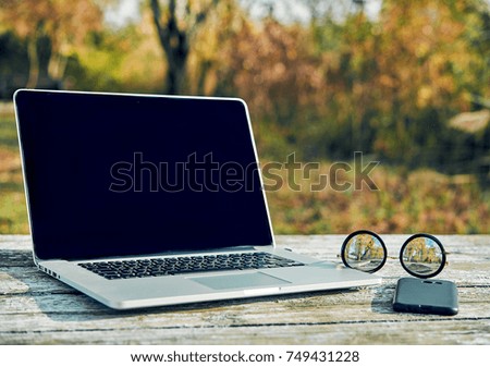 laptop on wooden table on nature