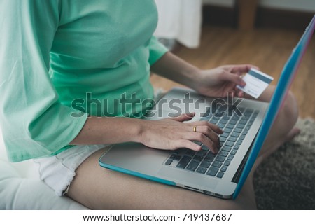 Young Asian woman using laptop computer for online shopping on weekend. Online banking and internet of things concept with photo filter effect