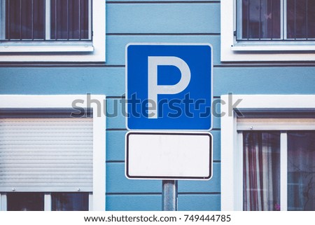 blue parking traffic sign on building background