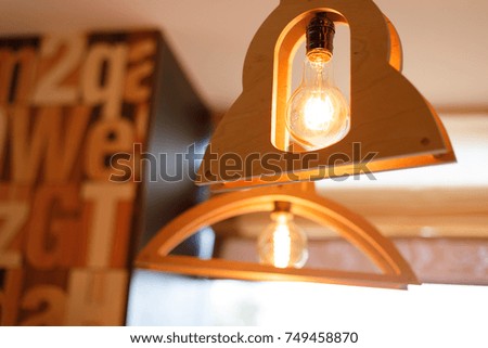 Two decoration ofhanger and a light bulb hangs on the ceiling instead of a lamp.