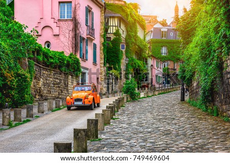 View of old street in quarter Montmartre in Paris, France. Cozy cityscape of Paris. Architecture and landmarks of Paris.  Royalty-Free Stock Photo #749469604