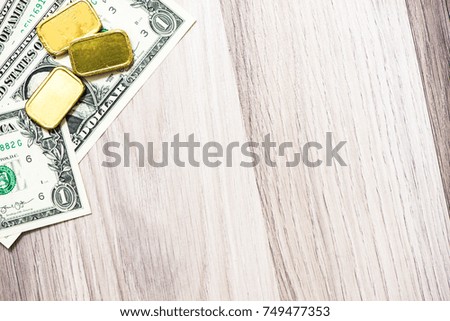 Banknote with gold bar on wooden background, business finance concept