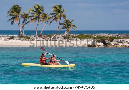 Two people kayaking in the Caribbean sea. Young happy couple traveling on a row boat. Recreational activities on the water. Royalty-Free Stock Photo #749491405