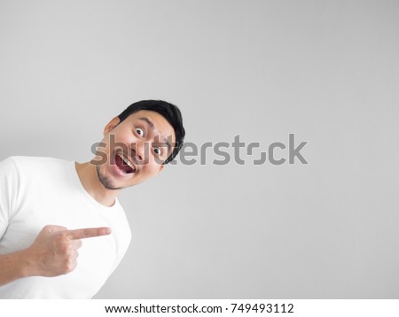 Surprised face of happy asian man in white shirt  light grey background.