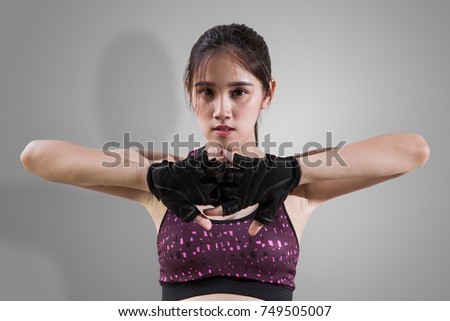 Portrait of young beautiful fitness girl wearing gloves and ready for gym exercise