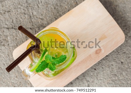 Passion Fruit Mojito with slice lime and mint leaves on cutting board top view