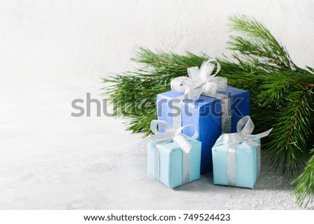 Christmas conceptual photo - gifts boxes with branch of fir over grey texture. copy paste