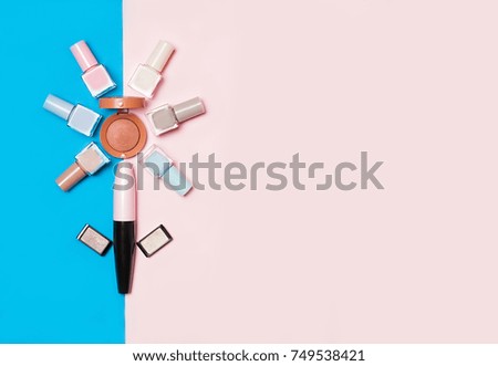 Beauty, decorative cosmetics. Makeup set and color nail polish on pink and blue background , flat lay, top view.