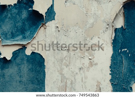 An old concrete wall with shabby, shabby, spoiled, blue paint. cracked wall