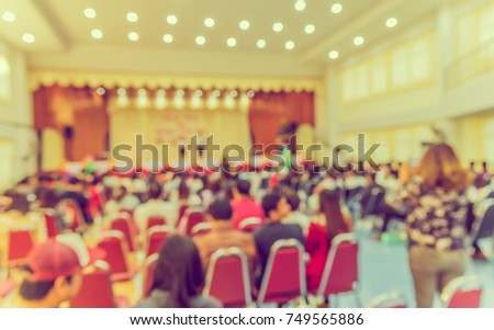 image of blur people looking to kid 's show on stage at school for background usage . (vintage tone)