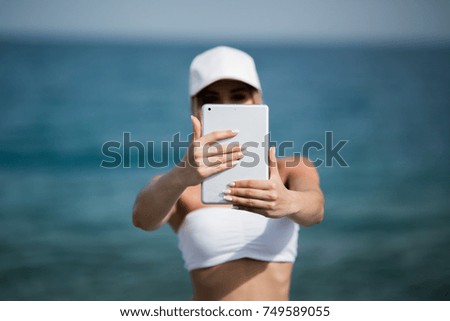 healthy gym blonde girl searches for new lifestyle fitness apps on her computer tablet