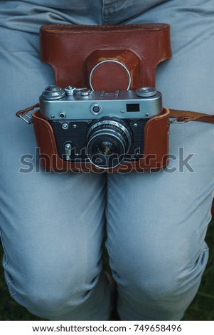 Girl with a vintage analog camera in her hands. Film camera. Closeup