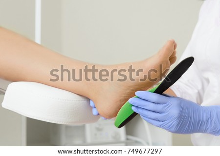 Orthopedic insoles. Fitting orthotic insoles. Flatfoot treatment. Podiatry clinic.  Royalty-Free Stock Photo #749677297