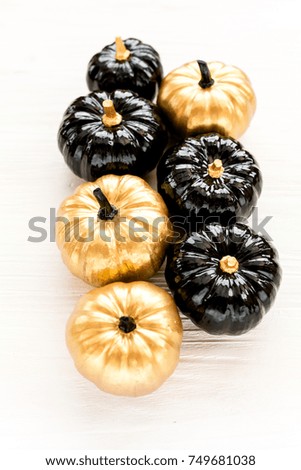 Stylish Halloween decorations. Decorative pumpkin black and gold Halloween isolated on white background. Flat lay, top view.