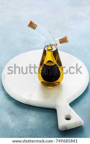 cruet with olive oil and balsamic vinegar on a blue board 