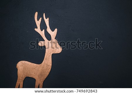 wooden carved deer on a black background, empty space on the right