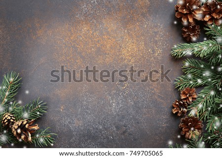 Christmas background with fir branches on a brown slate,stone or metal background.Top view with copy space.