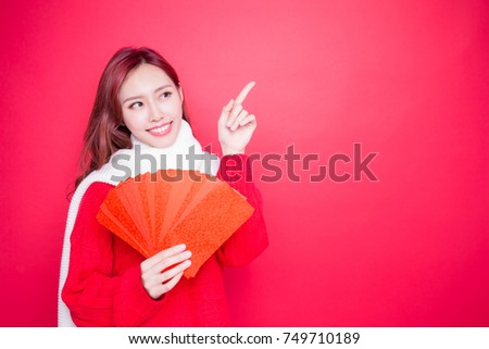 woman holding red envelope on the red background Royalty-Free Stock Photo #749710189