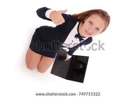 Happy student teenage girl with laptop. Sitting sideways and holding thumb up. Isolated on white