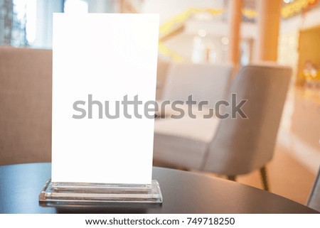 Mock up white Label for blank menu frame in Bar restaurant cafe., Stand for booklets with  sheets paper tent card on table cafeteria, blurred background insert for text of customer. Space for texting.