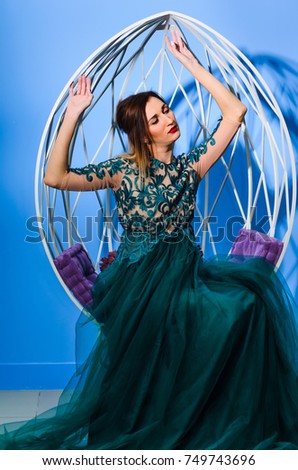 portrait of a woman dressed in Quinceanera dresses green . Photography Studio steel egg-shaped chair